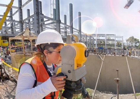 A female surveyor looking through a surveying instrument