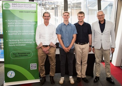Two young surveying and spatial scholarships holders standing with two other people