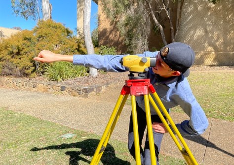 A high-school student operating a surveying instrument during the Let's Locate surveying immersion program