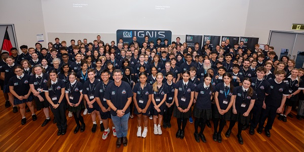 A group of high school students with an adult man standing in front, as they learn about the internship program