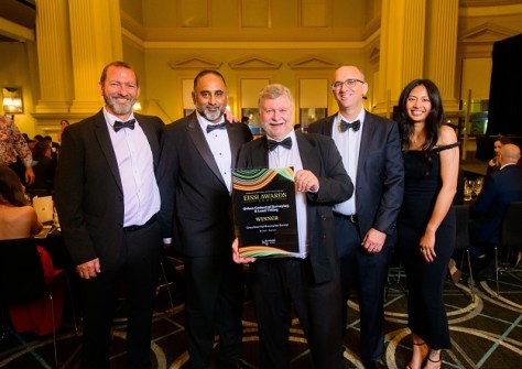 Five people standing together at the EISSI awards ceremony, with one of them holding the award
