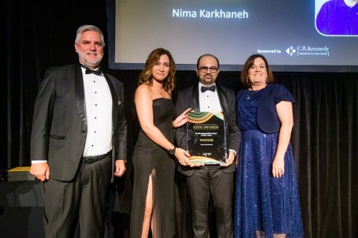 Four people standing together at the EISSI awards ceremony, with one of them holding the award