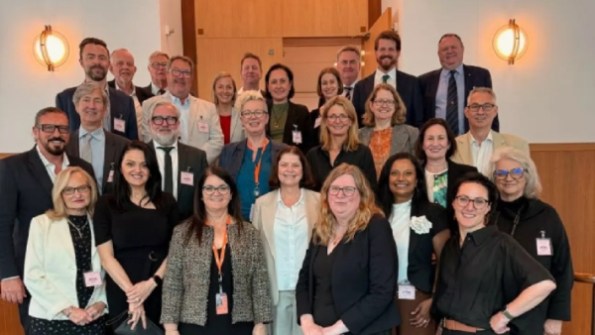 A group of 27 people posing for a photograph at Parliament House in Canberra, including a representative from RICS