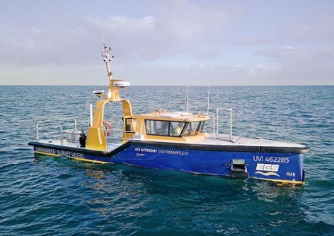 A small hydrographic survey vessel at sea, capable of autonomous operation