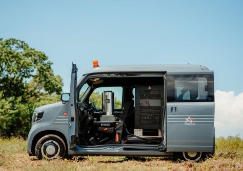 A small van with its side door open, revealing one of Atomionics quantum sensors
