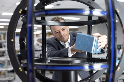 Pawel Michalak, who will working on positioning, navigation and timing systems, is seen holding a small metal box inside a spherical metal grid.