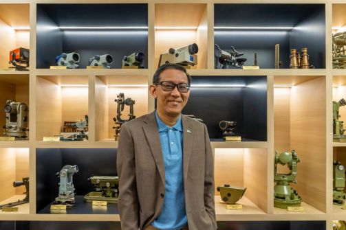 Dr Victor Khoo, the new Chief Surveyor of Singapore, standing in front of a bookshelf