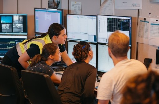 Four people looking at computer screens in a room inside the RV Investigator ship during the CAPSTAN voyage