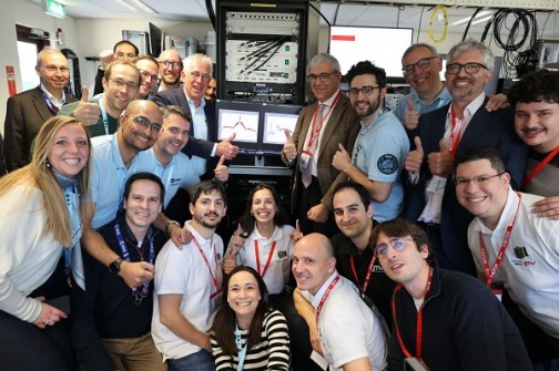 A group of about 20 people, smiling at the camera and giving thumbs up on the occasion of the launch of the first two Celeste satellites