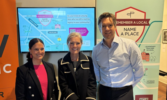 Three people from Gender Equity Victoria and government standing in front of gender equity displays