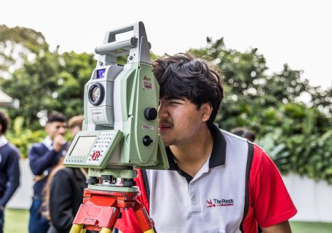 A student looking through a total station