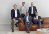Five members of the board of Bennett and Bennett Holdings sitting and leaning against a couch