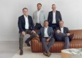 Five members of the board of Bennett and Bennett Holdings sitting and leaning against a couch