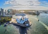 An aerial view of Sydney Opera House with the city and Harbour Bridge in the background