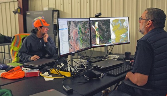 Two men looking at computer screens, studying hyperspectral imagery