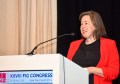 A woman speaking into a microphone at a lectern