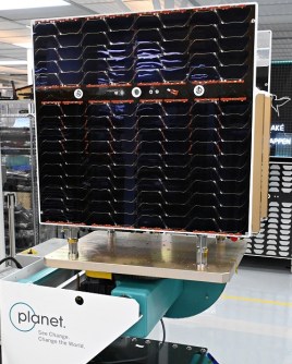A Pelican satellite with its solar panels folded, seen inside a clean room