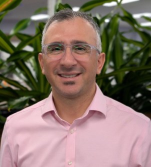A head-and-shoulders image of a man wearing glasses