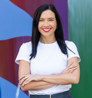 An upper-torso-and-head image of a smiling woman