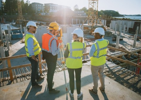 Four surveyors on a building site
