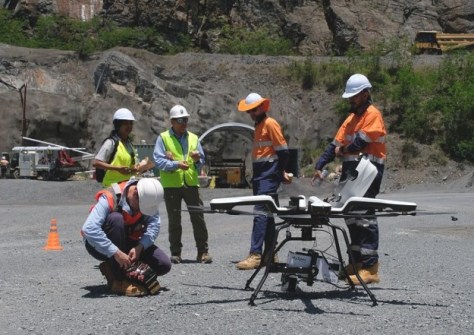 People standing near an aerial imaging drone inside a quarry