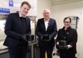 Three people, each holding in front of them a Binar CubeSat