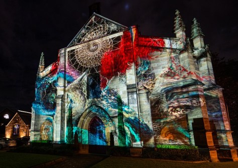 A church colourfully lit up at night using laser and LED displays during the Vivid festival
