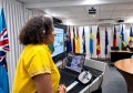 A woman standing at a lectern, making a presentation on coastal ecosystems