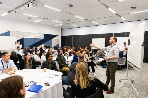 A room with a group of people seated, during a workshop session at the Locate conference