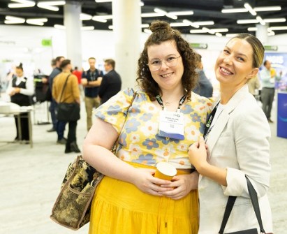 Two women smiling at the camera during the Locate conference