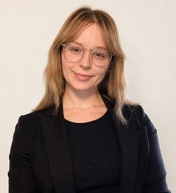 A head-and-shoulders image of a woman wearing glasses