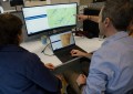 Three people at a desk, looking at the Bionet Atlas on a computer screen