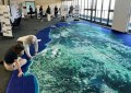 A Big Map laid out inside a hall, with two people on their hands and knees inspecting it