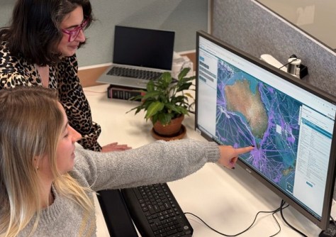 Two women looking at a computer screen, on which is displayed data from AusSeabed, a finalist in the running for one of the Spirit of Service Awards