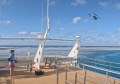 A person launching a drone from a boat to conduct a reef survey