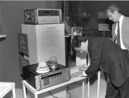 Charlie Trimble signing a document on a desk, next to GPS equipment