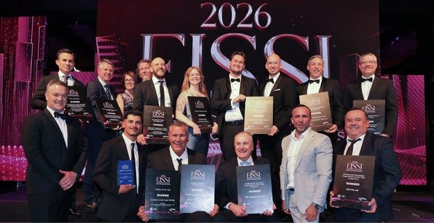 A group of about 15 people posing for a photo, holding EISSI awards plaques