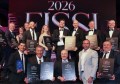 A group of people posing for a photo, holding award plaques