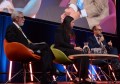 Three people seated on a stage as part of a spatial data panel discussion