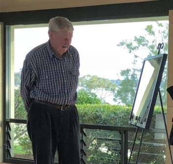 A man looking at a painting on an easel