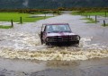 A car driving along a flooded road