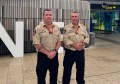 Two men in firefighter uniforms, standing inside an airport building, before heading to Nepal