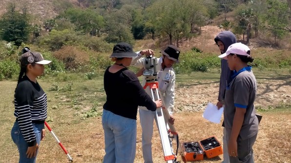 Four people using a total station in Timor-Leste