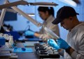 A man and a woman working at an electronics workbench at Advanced Navigation