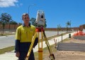 Shaun Sergeant, a TAFE NSW surveying student, standing next to a total station