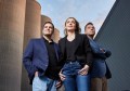 Three people standing in front of grain silos